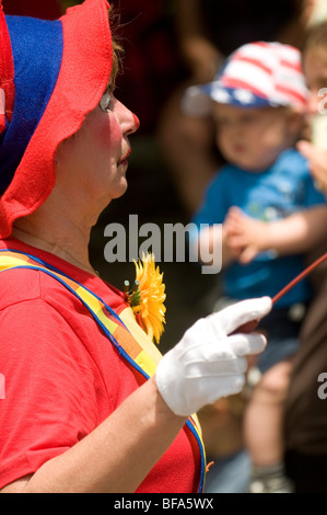 Frau Clown in bunten Kostümen in Rhode Island Fourth Of July Parade. Stockfoto