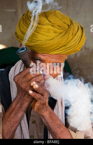 Rajput Mann raucht eine Pfeife auf der Camel Fair in Pushkar Indien Stockfoto