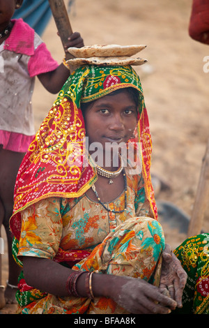 Mädchen machen Chapati und kühlen sie auf dem Kopf auf der Camel Fair in Pushkar Indien Stockfoto