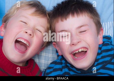 Ein Model Release Bild von zwei Brüder (10 und 6) Lachen drinnen im Vereinigten Königreich Stockfoto