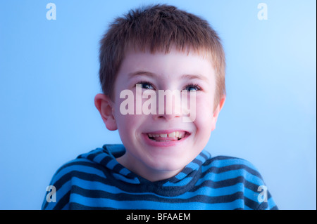 Ein Model Release Bild eines zehn Jahre alten Jungen Lachen in seinem Schlafzimmer im Vereinigten Königreich Stockfoto