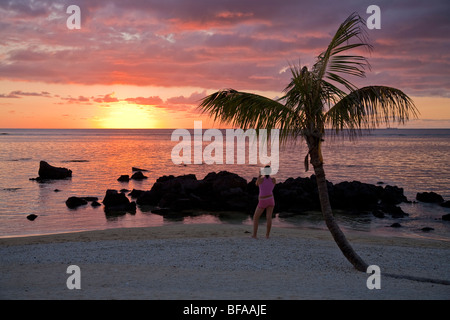 Sonnenuntergang mit Fotograf und Palm Tree am Strand von Pointe Aux Piments, Le Victoria Hotel Mauritius Stockfoto