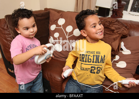 2 Brüder im Alter von 3 und 6 spielen Nintendo Wii Stockfoto