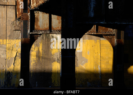 Gelbe Wand unter Eisenbahnviadukt Stockfoto