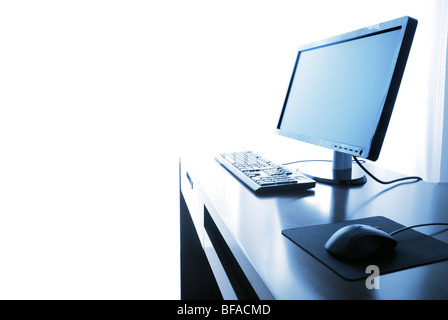 Büroalltag, Computer mit Schreibtisch isoliert auf die weiss - blau getönt. Stockfoto