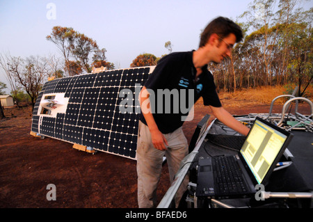 Ingenieur mit seinem Computer um zu überprüfen, die Menge von Energie erzeugt durch seine Solarmodule von seinem solar Auto. Stockfoto