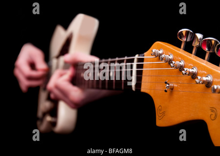 Electric jazz Akustikgitarre mit unscharfen Händen gespielt wird, isoliert auf schwarz. Stockfoto