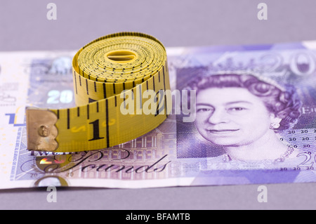 Rolle von Maßband über eine britische zwanzig Pfund-banknote Stockfoto
