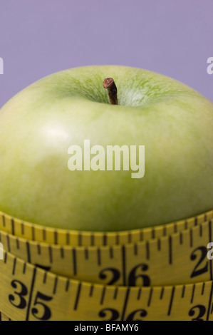 Maßband umwickelt einen grünen Apfel Stockfoto