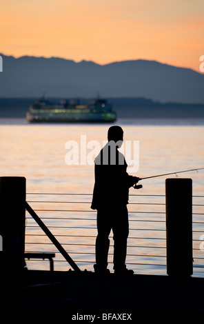 Ein Fischer hofft auf einen vorbeifahrenden Lachs zu fangen, wie es seinen Weg durch Elliott Bay, Seattle, um die Duamish und Green River macht. Stockfoto