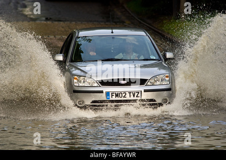 Kraftfahrzeuge, die Fahrt durch ein überflutet Wehr Stockfoto