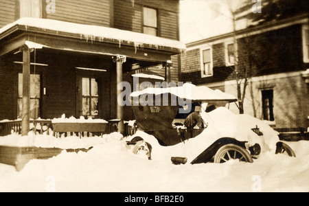 Schnee bedeckt Auto parkte vor Haus Stockfoto