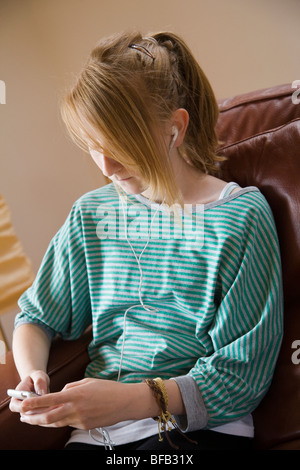 Ein junges Mädchen entspannt sich, während Sie Musik auf ihrem MP3-Player hören. Stockfoto