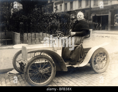 Große alte Dame winzige Auto fahren Stockfoto