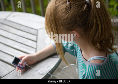 Ein junges Mädchen entspannt sich, während Sie Musik auf ihrem MP3-Player hören. Stockfoto