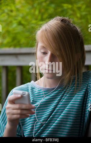 Ein junges Mädchen entspannt sich, während Sie Musik auf ihrem MP3-Player hören. Stockfoto