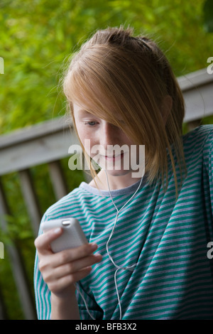 Ein junges Mädchen entspannt sich, während Sie Musik auf ihrem MP3-Player hören. Stockfoto