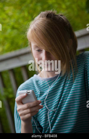 Ein junges Mädchen entspannt sich, während Sie Musik auf ihrem MP3-Player hören. Stockfoto