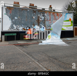 -Schaden Plakatwand mit Postboten übergeben. Bromley, London, England, UK. Stockfoto
