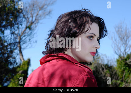 Junge dunkelhaarige Brünette Frau außerhalb, über die Schulter schauen. Stockfoto