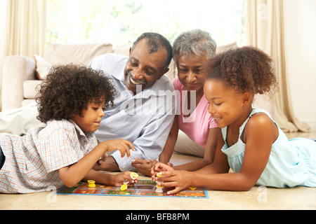 Großeltern spielen Brettspiel zu Hause mit Enkel Stockfoto
