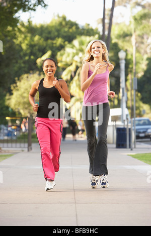 Zwei Freundinnen Joggen auf der Straße Stockfoto