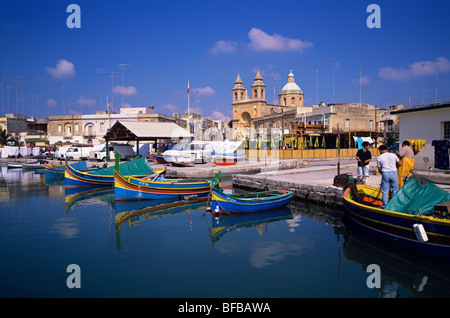 Fischer Reparatur Netze am Kai des malerischen Fischerdorf Port von Marsaxlokk Stockfoto