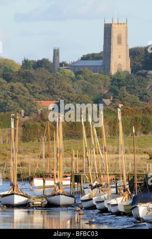 Boote in Morston Hafen, Blakeney Kirche in Ferne, North Norfolk, UK, Oktober Stockfoto