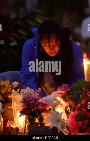 Frau, Blumen auf dem Friedhof auf Allerheiligen in Hanga Roa in Osterinsel, Chile. Stockfoto