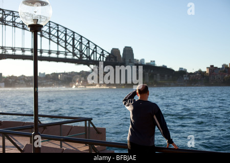 Ein Mann blickt auf Sydney Harbour von der Oper entfernt. Stockfoto