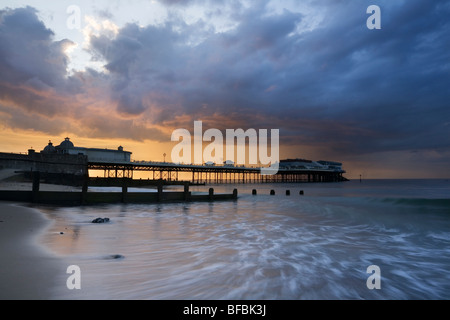 Cromer Pier mit Sommer Sturm Wolken bei Sonnenuntergang. Stockfoto