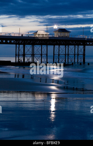 Zwei Unterstände auf Cromer Pier mit Lichtern in der Flut Wasser reflektiert. Stockfoto