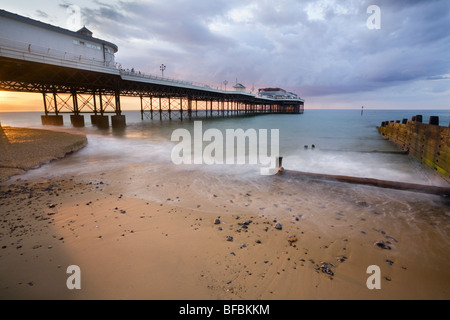 Cromer Pier mit Sommer Sturm Wolken bei Sonnenuntergang mit Hintergrundbeleuchtung-Spray. Stockfoto