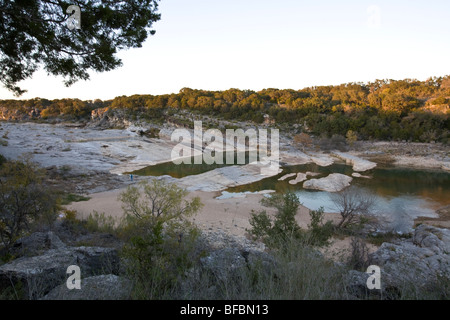 Pedernales Falls State Park, wo der Fluss über fließt, Treppenstufen geschichtete Kalkstein unter Klippen gekippt Stockfoto