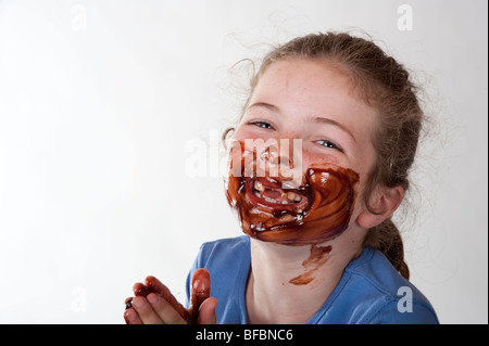 kleines Mädchen mit Schokolade bedeckte Gesicht lachen Stockfoto