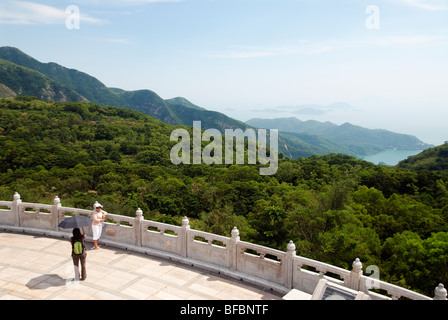 Blick vom Tian Tan Big Buddha mit Frau posiert für ein Foto, Lantau Island, Hong Kong Stockfoto