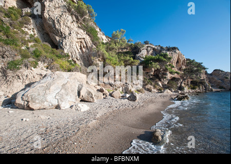 Sonnigen und sandigen Strand mit Felsen und Klippen auf einer griechischen Insel Stockfoto