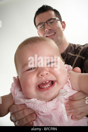 Vater Tochter auf Armlänge, Tochter weinend vor Lachen halten Stockfoto