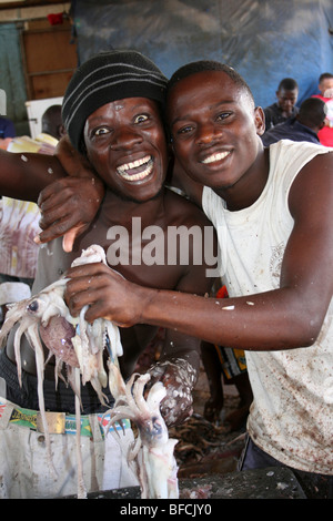 Junge Männer mit gemeinsamen Octopus zum Verkauf an Kivukoni Fischmarkt, Dar-Es-Salaam, Tansania Stockfoto