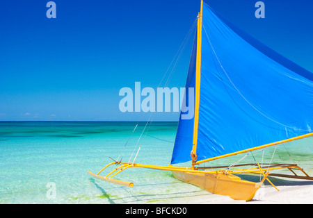 Boot mit blauen Segel in Untiefen Boracay gelb; Die Visayas; Philippinen Stockfoto