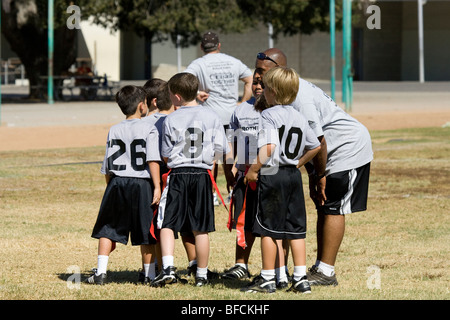 Junge flag Football-Spieler erhalten Anweisungen vom Trainer Stockfoto