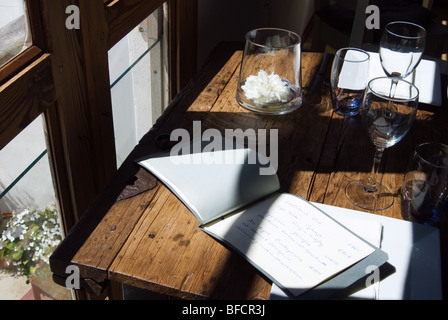 Rustikaler Tisch mit Gläsern und Menüs. Stockfoto