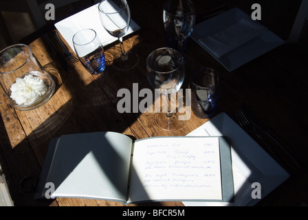 Rustikaler Tisch mit Gläsern und Menüs. Stockfoto