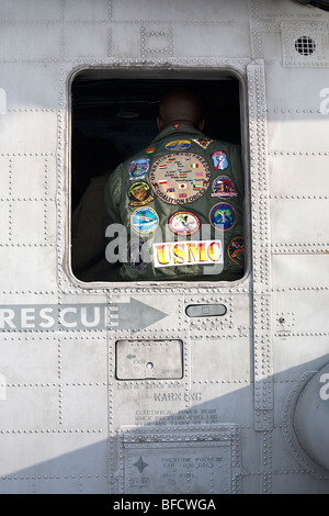 Schließen Sie Ansicht USMC Abzeichen genäht auf der Rückseite der Marines Jacke umrahmt von Fenster der Kampfhubschrauber auf dem Deck der USS New York Stockfoto