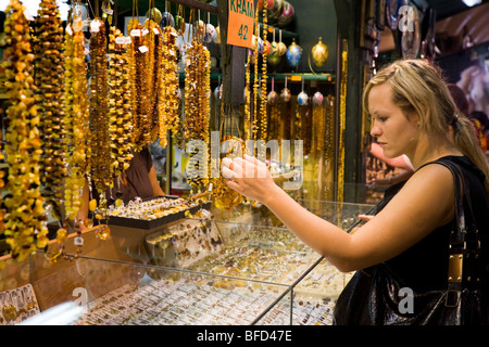 Frau Tourist Auswahl Schmuck an ein Geschenk-Stand in der Sukiennice (Tuchhallen, Tuchmacher Hall) auf dem Marktplatz. Krakau. Polen. Stockfoto