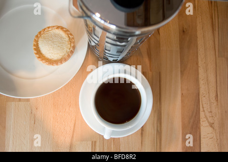 Tasse schwarzen Kaffee und ein Apfelkuchen, serviert auf Buche Tischplatte. Stockfoto