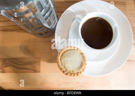 Tasse schwarzen Kaffee und ein Apfelkuchen, serviert auf Buche Tischplatte. Stockfoto