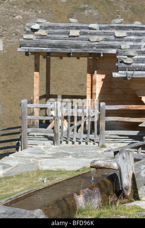 Tränke mit traditionellen Berghütte mit Dachsteinen, halten Sie die hölzernen Fliese oder Schindeldach. Italienische Alpen Stockfoto