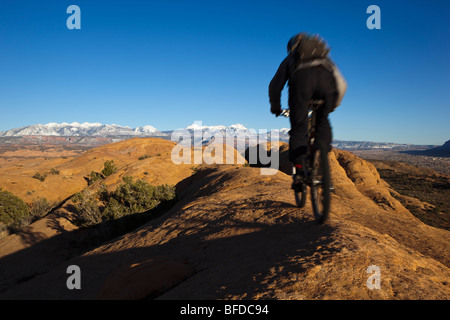 Mountainbiker auf dem Slickrock Trail in Moab, Utah mit Blick auf ferne Berge Reiten. Stockfoto