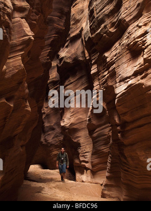 Ein Mann schaut beim Wandern in einem Slotcanyon in Utah. Stockfoto
